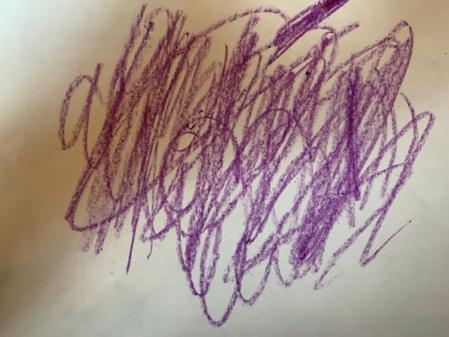 Child's writing has up-and-down scribbles and some rounded strokes