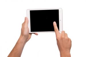Hands holding up a tablet computer.