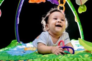 A smiling infant playing with toys.