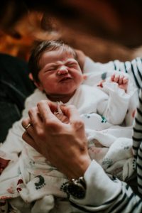 An infant making an angry facial expression.