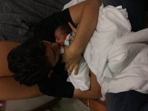 The formation of attachment in action as a father snuggles a newborn.