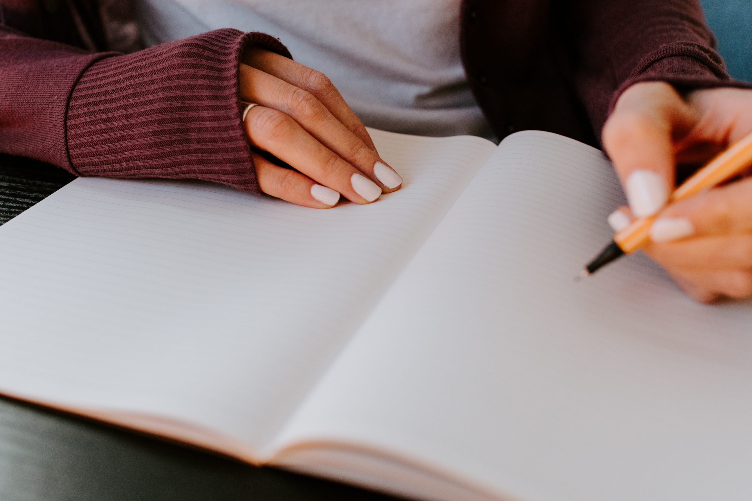 Photo of a woman writing in a book.