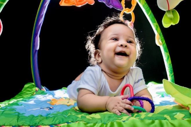 A smiling infant playing with toys.