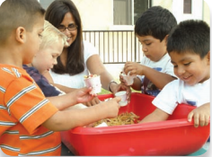 Children play together as an adult watches.