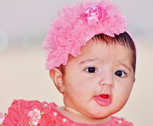 A child wearing pink clothing and pink hair accessory.
