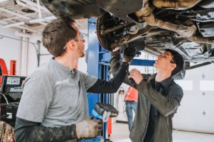 faculty and student working on a car for an automotive project