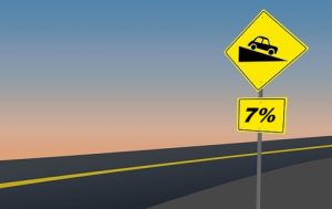 A road sign indicating that the road ahead has a grade of 7 percent.