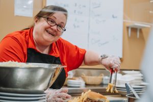 culinary student smiling, serving food