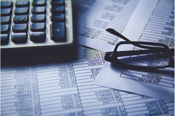 Photo of a calculator and spreadsheets.