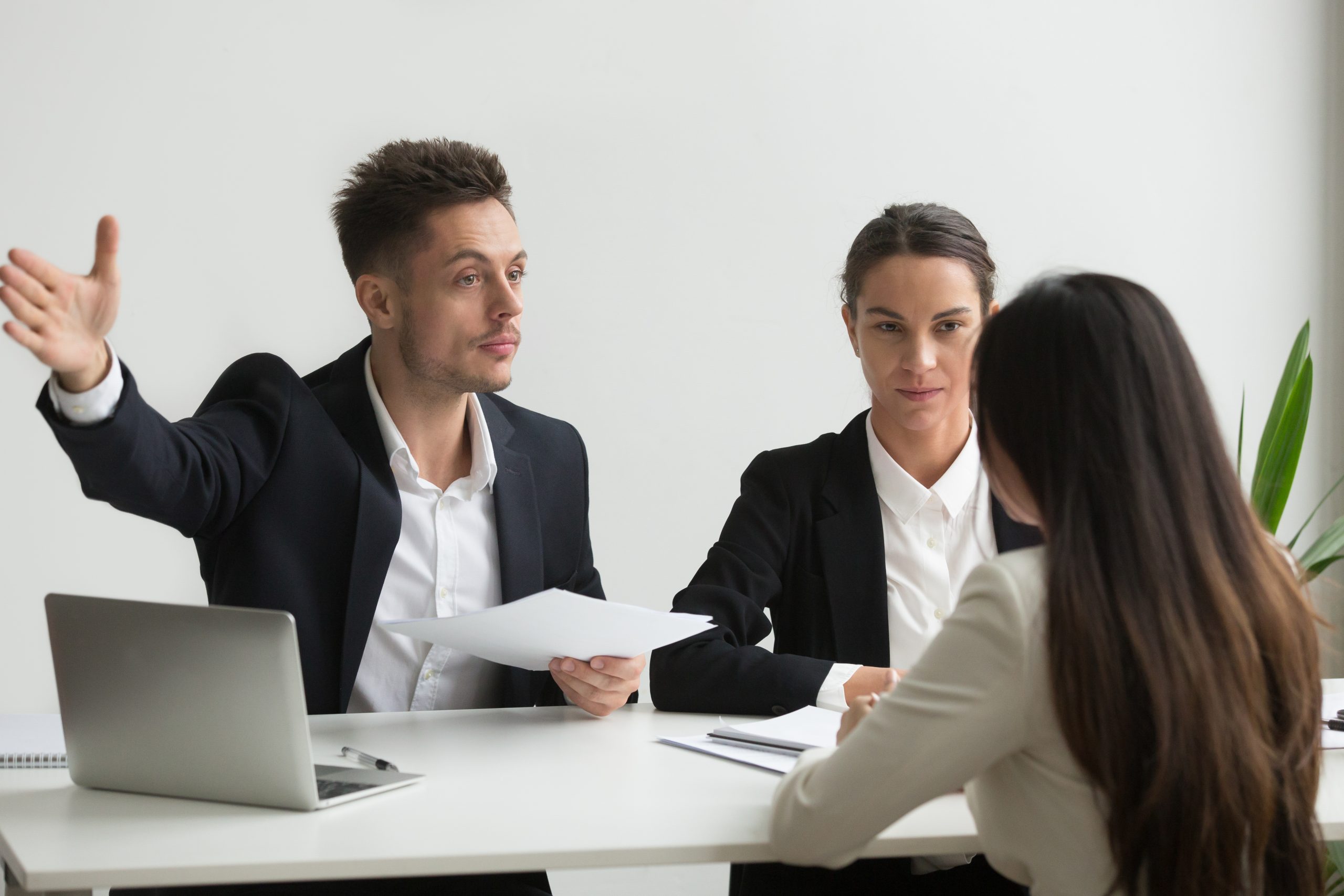 Male HR manager pointing at door, asking female job candidate to leave,