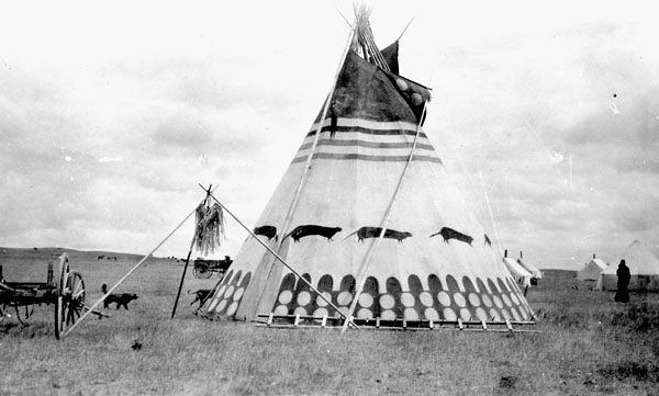 black and white image depicts moyís in the foreground, a conical structure with painted designs
