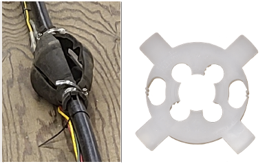 A torque arrestor (left) and a cable guard (right). The torque arrestor is made of two rubber pieces and two stainless steel gear clamps, one on either side. The two sides with the gear clamps are thinner than the middle of the torque arrestor, creating a diamond-like shape. The cable guard is made of plastic and is circular with four rectangles jutting out diagonally. Inside the circle, there are two cutouts on the sides and one large cutout in the centre, which guides and guards the cables.