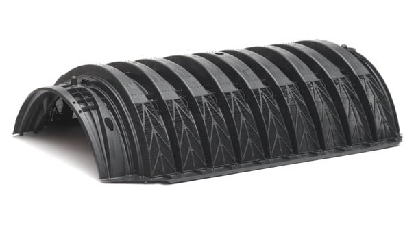 An infiltrator chamber, which is a long black semi-circular pipe with ridges.