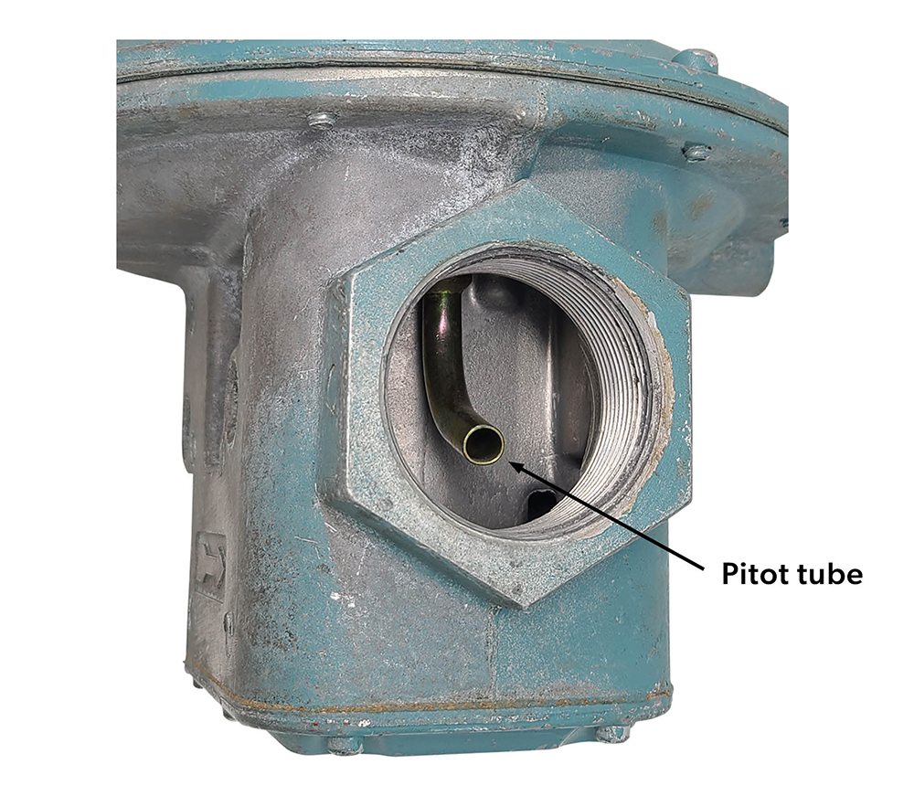 Image of a regulator, highlighting the pitot tube. It is a small, curved tube that is seen through the exit of the valve body.