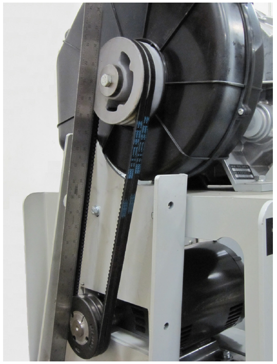 Two belt pulleys with a belt connecting them. A metal ruler is being held up to the belt to check its alignment.